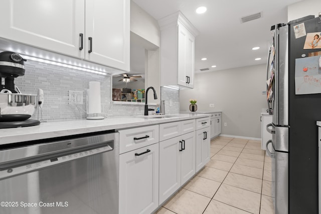 845 Westport Dr, Rockledge, FL 32955 - kitchen with appliances with stainless steel finishes, decorative backsplash, a ceiling fan, white cabinets, and light tile patterned flooring