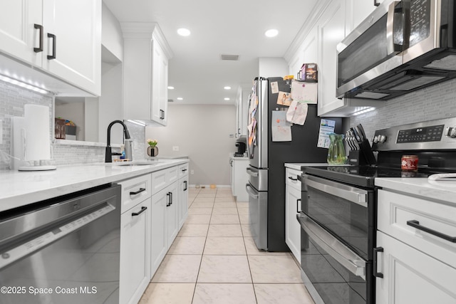 845 Westport Dr, Rockledge, FL 32955 - kitchen featuring appliances with stainless steel finishes, tasteful backsplash, white cabinetry, recessed lighting, and light stone countertops