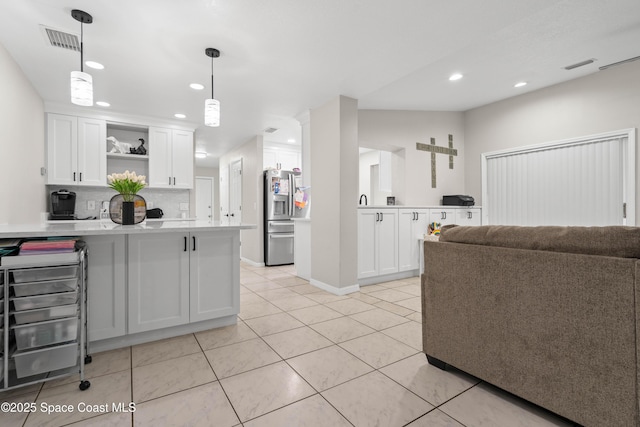 845 Westport Dr, Rockledge, FL 32955 - kitchen with stainless steel fridge, a peninsula, open shelves, light countertops, and white cabinetry