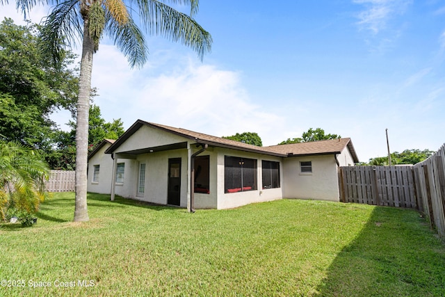 845 Westport Dr, Rockledge, FL 32955 - rear view of house with stucco siding, a fenced backyard, and a sunroom
