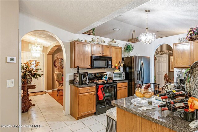 2595 Diane Ave SE, Palm Bay, FL 32909 - kitchen featuring black appliances, vaulted ceiling, a chandelier, dark countertops, and arched walkways