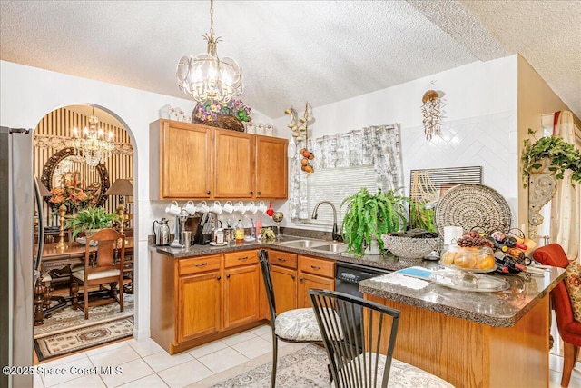 2595 Diane Ave SE, Palm Bay, FL 32909 - kitchen with a chandelier, a textured ceiling, freestanding refrigerator, dark countertops, and brown cabinets