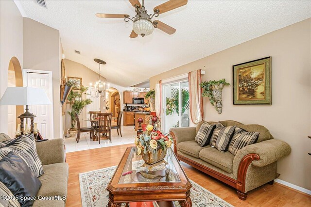 2595 Diane Ave SE, Palm Bay, FL 32909 - living area with arched walkways, a ceiling fan, lofted ceiling, a chandelier, and a textured ceiling