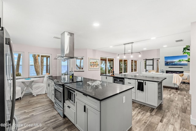 1379 Rose Ct, Melbourne, FL 32935 - kitchen featuring a center island, island exhaust hood, open floor plan, light wood finished floors, and stainless steel appliances