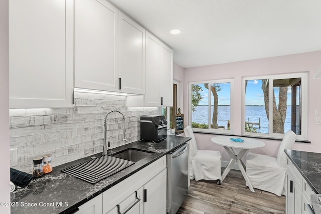 1379 Rose Ct, Melbourne, FL 32935 - kitchen featuring dishwasher, backsplash, white cabinetry, wood finished floors, and dark stone countertops