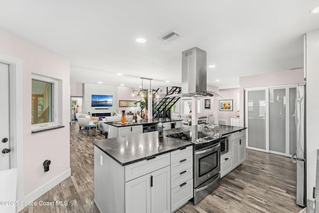 1379 Rose Ct, Melbourne, FL 32935 - kitchen with stainless steel appliances, dark countertops, island range hood, open floor plan, and a kitchen island