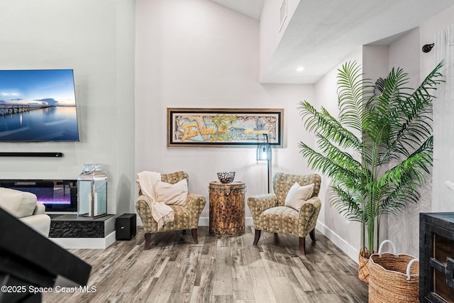 1379 Rose Ct, Melbourne, FL 32935 - sitting room featuring a glass covered fireplace and wood finished floors