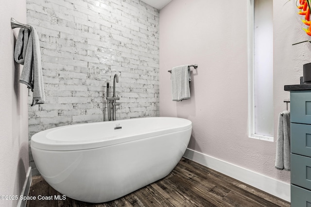 1379 Rose Ct, Melbourne, FL 32935 - bathroom with a freestanding bath and wood finished floors