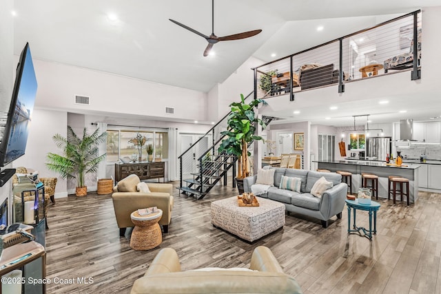 1379 Rose Ct, Melbourne, FL 32935 - living area featuring high vaulted ceiling, light wood-type flooring, stairs, a ceiling fan, and recessed lighting