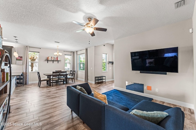 2920 Casterton Dr, Melbourne, FL 32940 - living area with ceiling fan, a chandelier, wood finished floors, and a textured ceiling