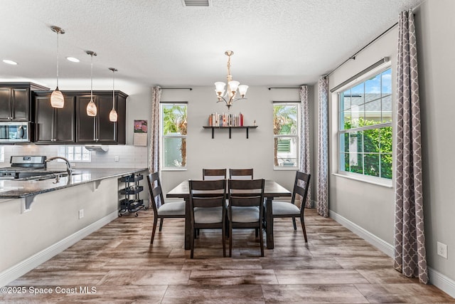 2920 Casterton Dr, Melbourne, FL 32940 - dining space featuring a textured ceiling, a chandelier, wood finished floors, and recessed lighting