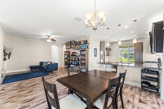 2920 Casterton Dr, Melbourne, FL 32940 - dining room featuring light wood-style floors, ceiling fan, a chandelier, arched walkways, and recessed lighting