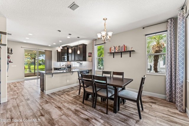 2920 Casterton Dr, Melbourne, FL 32940 - dining room featuring a chandelier, light wood-style floors, healthy amount of natural light, a textured ceiling, and recessed lighting