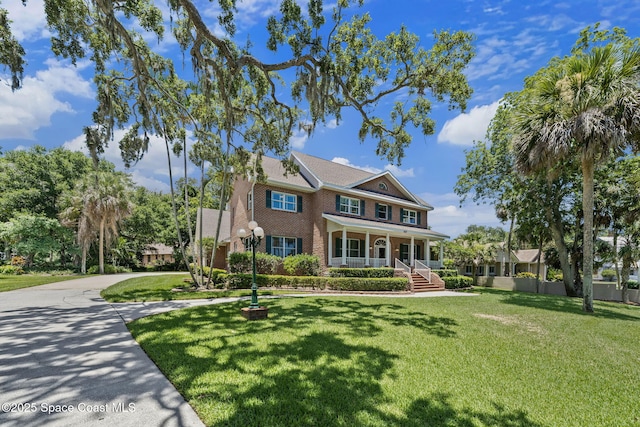 1407 Rockledge Dr, Rockledge, FL 32955 - view of front of home with a porch, brick siding, and a front yard