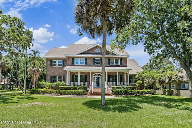 1407 Rockledge Dr, Rockledge, FL 32955 - view of front of home with brick siding, a front lawn, and covered porch