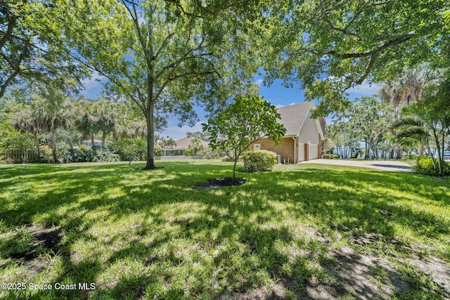 1407 Rockledge Dr, Rockledge, FL 32955 - view of green lawn featuring a garage and concrete driveway