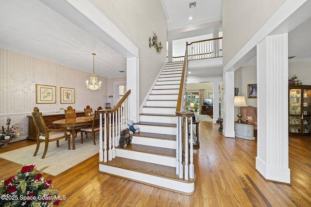 1407 Rockledge Dr, Rockledge, FL 32955 - staircase featuring wood finished floors, crown molding, a chandelier, and a high ceiling