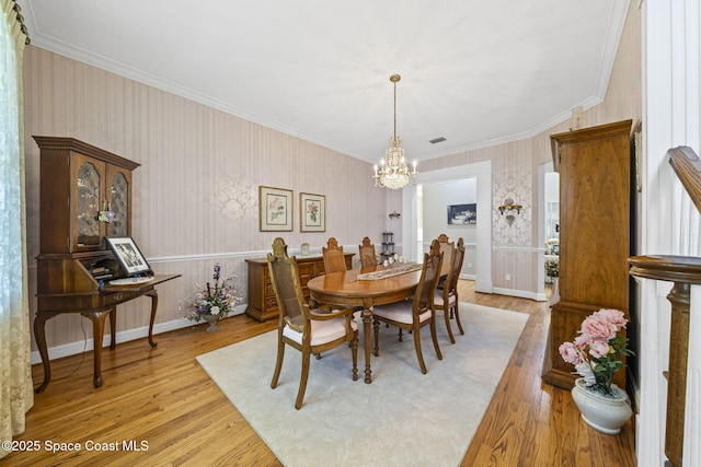 1407 Rockledge Dr, Rockledge, FL 32955 - dining space with a chandelier, light wood-type flooring, crown molding, and wallpapered walls