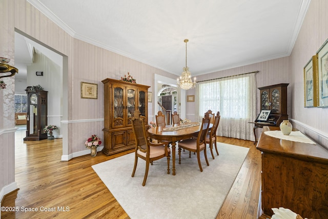1407 Rockledge Dr, Rockledge, FL 32955 - dining space featuring wallpapered walls, a chandelier, crown molding, light wood finished floors, and a wainscoted wall
