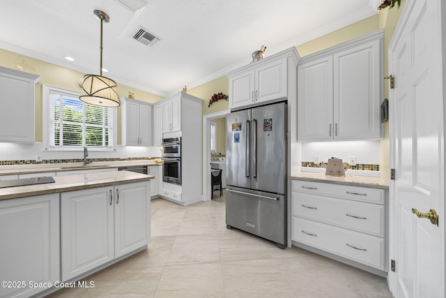 1407 Rockledge Dr, Rockledge, FL 32955 - kitchen with stainless steel appliances, ornamental molding, decorative light fixtures, light stone countertops, and white cabinets