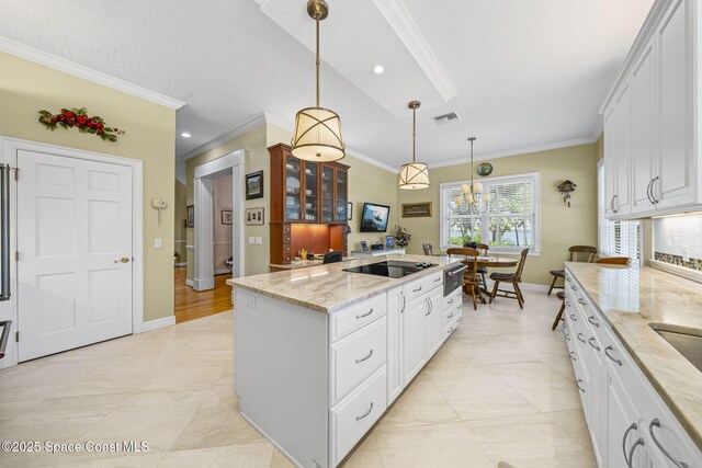 1407 Rockledge Dr, Rockledge, FL 32955 - kitchen featuring ornamental molding, a center island, white cabinetry, decorative light fixtures, and light stone counters