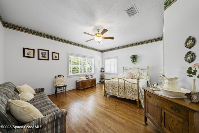 1407 Rockledge Dr, Rockledge, FL 32955 - bedroom featuring wood finished floors, a textured ceiling, and a ceiling fan