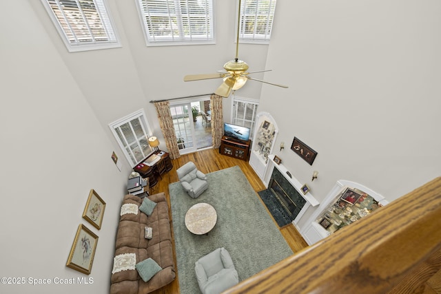 1407 Rockledge Dr, Rockledge, FL 32955 - living area with a towering ceiling, wood finished floors, a ceiling fan, and a fireplace with flush hearth