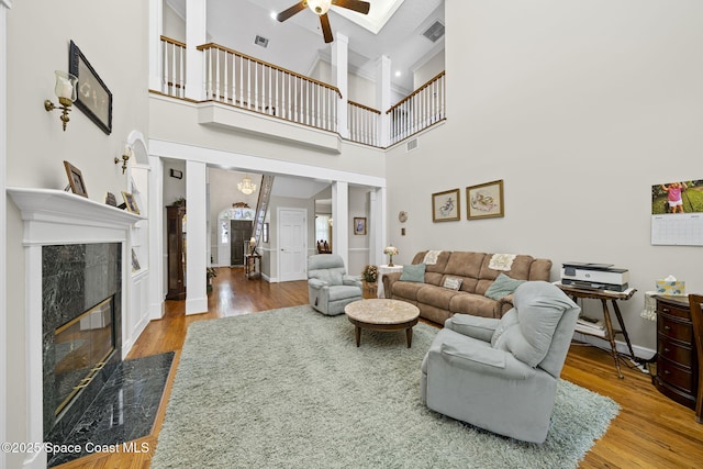 1407 Rockledge Dr, Rockledge, FL 32955 - living area with ceiling fan, wood finished floors, a towering ceiling, and a fireplace