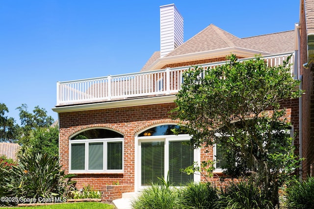 1407 Rockledge Dr, Rockledge, FL 32955 - back of property with brick siding, a balcony, and a chimney