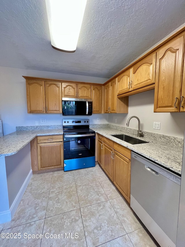 1917 Vista Oaks Cir NE, Palm Bay, FL 32905 - kitchen with appliances with stainless steel finishes, a textured ceiling, light tile patterned floors, brown cabinetry, and light stone countertops