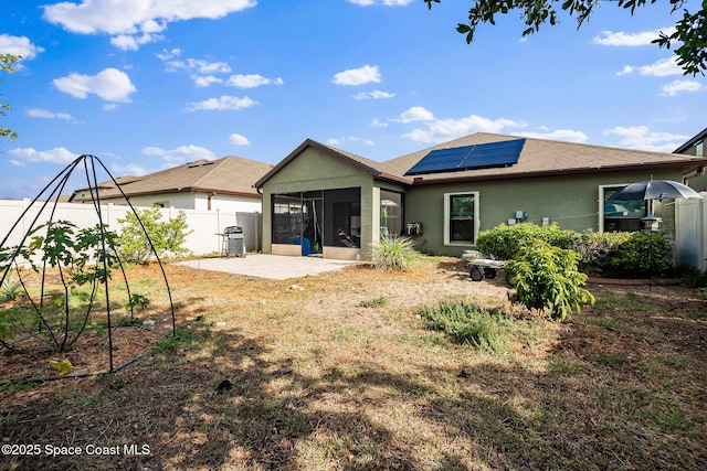 980 Dillard Dr SE, Palm Bay, FL 32909 - rear view of property with a sunroom, solar panels, a patio area, roof with shingles, and stucco siding