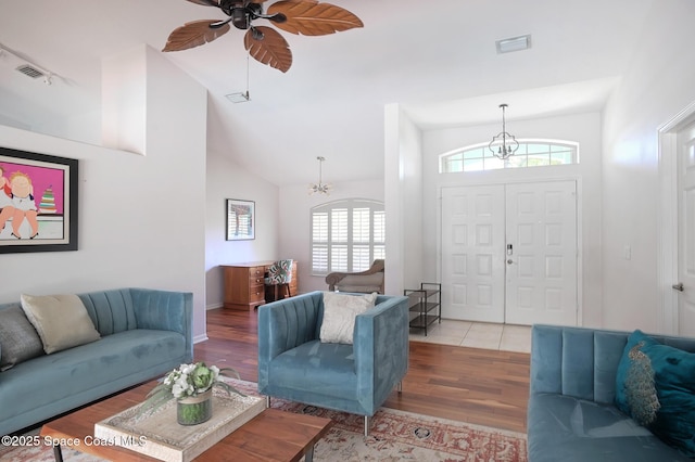 112 Carmen St, Melbourne Beach, FL 32951 - living room featuring healthy amount of natural light, wood finished floors, ceiling fan, lofted ceiling, and a chandelier