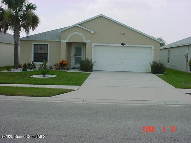 4240 Swanna Dr, Melbourne, FL 32901 - ranch-style home with concrete driveway, an attached garage, a front yard, and stucco siding