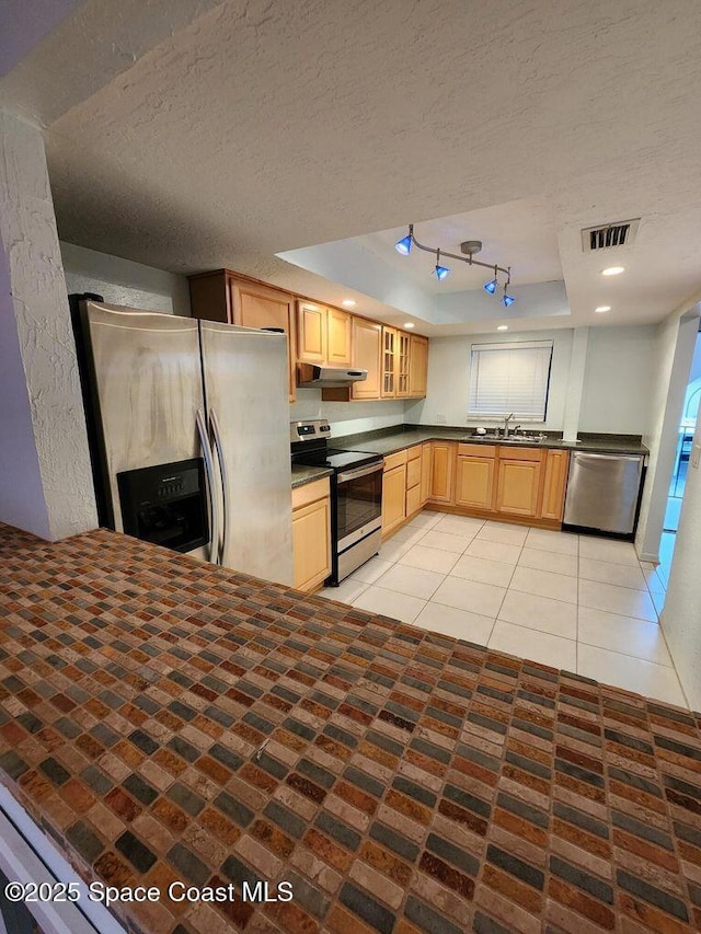 5807 N Atlantic Ave Unit 322, Cape Canaveral, FL 32920 - kitchen featuring appliances with stainless steel finishes, dark countertops, a textured ceiling, glass insert cabinets, and light brown cabinetry