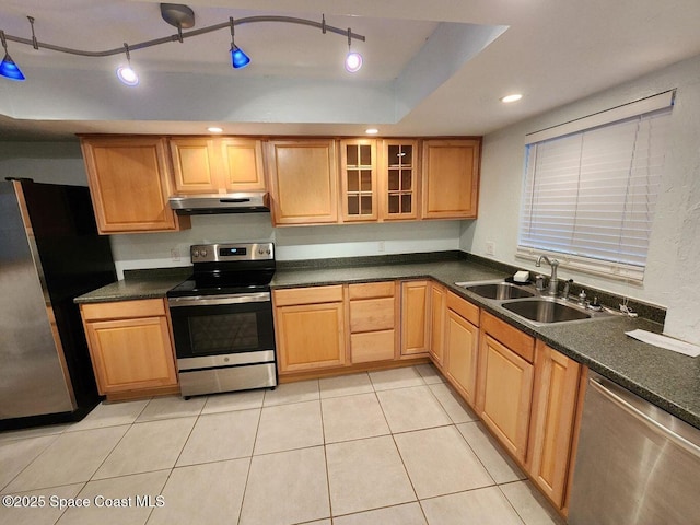 5807 N Atlantic Ave Unit 322, Cape Canaveral, FL 32920 - kitchen featuring stainless steel appliances, under cabinet range hood, dark countertops, light tile patterned floors, and glass insert cabinets