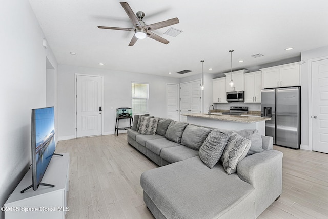 443 Archer Rd SE, Palm Bay, FL 32909 - living area featuring light wood-style flooring, a ceiling fan, and recessed lighting
