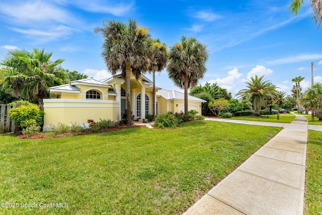 174 Martesia Way, Indian Harbour Beach, FL 32937 - view of front of property featuring concrete driveway, a front lawn, an attached garage, stucco siding, and a metal roof