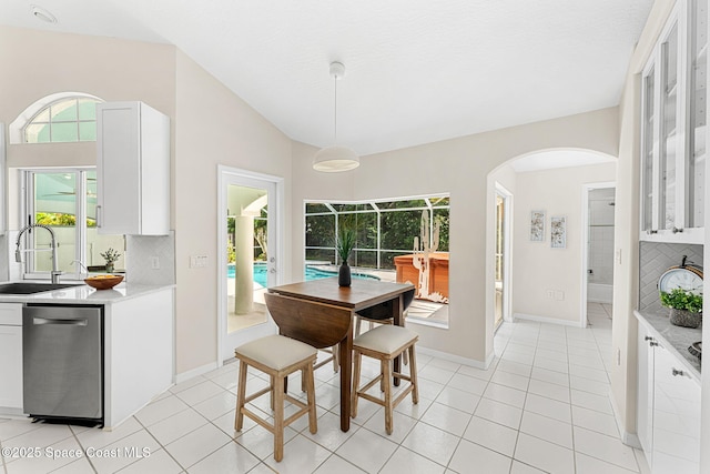 174 Martesia Way, Indian Harbour Beach, FL 32937 - dining room with arched walkways, plenty of natural light, light tile patterned floors, and lofted ceiling