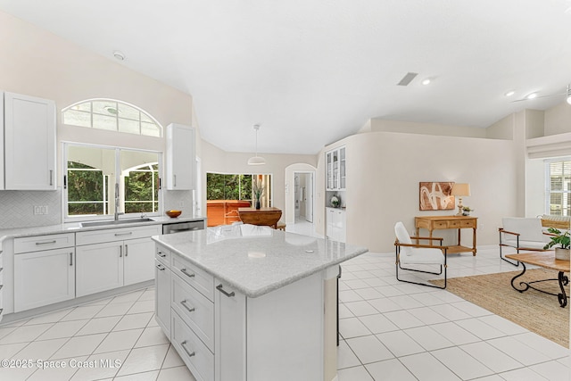 174 Martesia Way, Indian Harbour Beach, FL 32937 - kitchen with vaulted ceiling, arched walkways, decorative backsplash, a center island, and light tile patterned floors