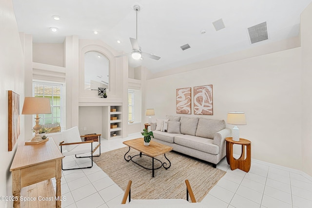 174 Martesia Way, Indian Harbour Beach, FL 32937 - living area with light tile patterned flooring, built in shelves, a ceiling fan, and high vaulted ceiling