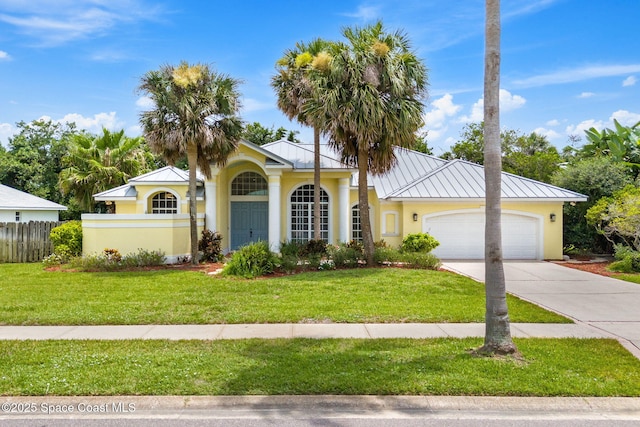 174 Martesia Way, Indian Harbour Beach, FL 32937 - view of front of house with a standing seam roof, driveway, an attached garage, stucco siding, and a metal roof