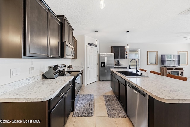 5071 Talbot Blvd, Cocoa, FL 32926 - kitchen with stainless steel appliances, dark brown cabinetry, light tile patterned floors, light countertops, and a textured ceiling
