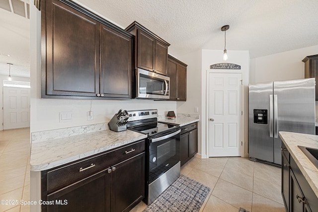 5071 Talbot Blvd, Cocoa, FL 32926 - kitchen with stainless steel appliances, light tile patterned floors, dark brown cabinetry, decorative light fixtures, and a textured ceiling