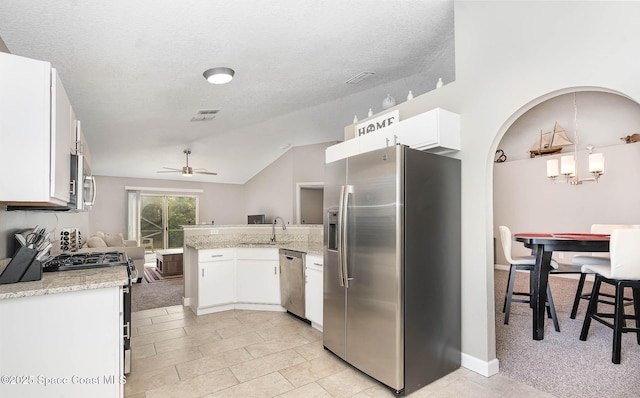 2221 Spring Creek Cir, Palm Bay, FL 32905 - kitchen with appliances with stainless steel finishes, a peninsula, a ceiling fan, white cabinets, and lofted ceiling