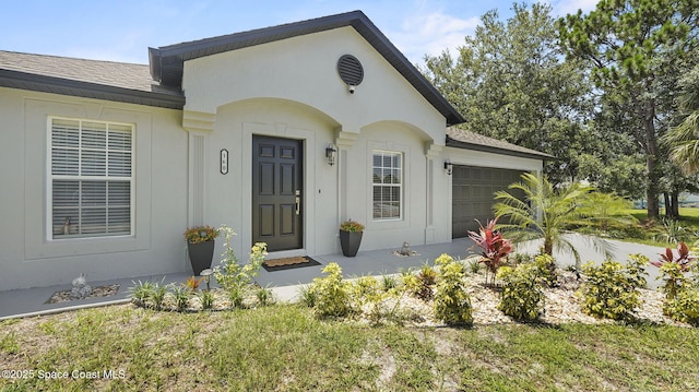 160 Eureka Ave NE, Palm Bay, FL 32907 - view of exterior entry with a garage and a shingled roof