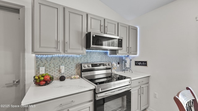 160 Eureka Ave NE, Palm Bay, FL 32907 - kitchen featuring stainless steel appliances, gray cabinetry, tasteful backsplash, light countertops, and lofted ceiling