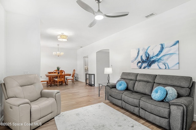 1014 Pelican Ln, Rockledge, FL 32955 - living room featuring light wood finished floors, ceiling fan, arched walkways, and a chandelier