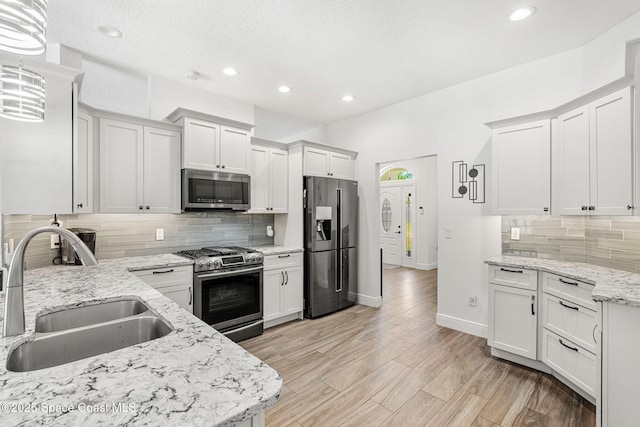 1014 Pelican Ln, Rockledge, FL 32955 - kitchen featuring appliances with stainless steel finishes, backsplash, recessed lighting, light stone counters, and white cabinetry