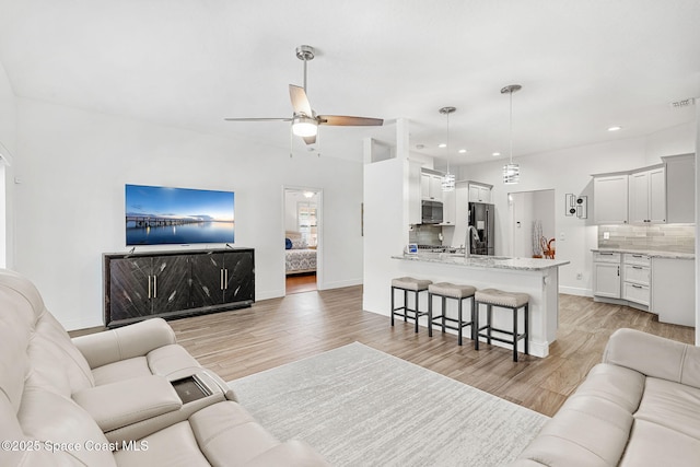 1014 Pelican Ln, Rockledge, FL 32955 - living room with light wood-style floors, ceiling fan, and recessed lighting