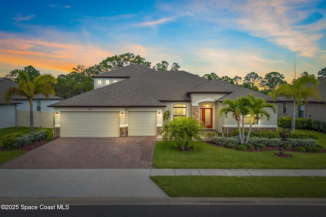 3550 Salt Marsh Cir, West Melbourne, FL 32904 - view of front of property with stone siding, an attached garage, driveway, stucco siding, and roof with shingles